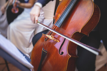 Concert view of a contrabass violoncello player with vocalist and musical band during jazz orchestra band performing music, violoncellist cello jazz player on stage