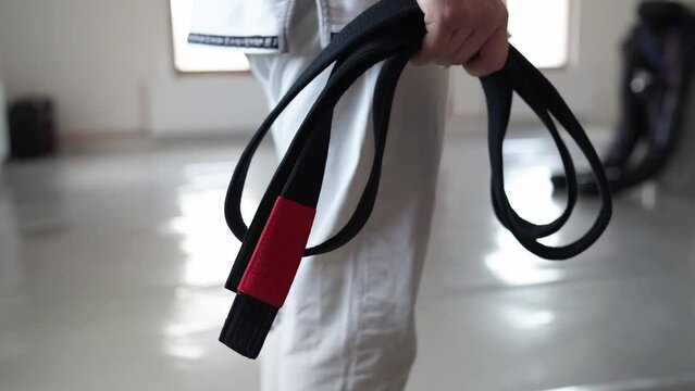 brazilian jiu jitsu bjj black belt male athlete holding belt at gym training sport self defence concept