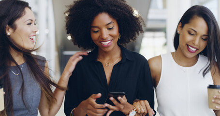 Connecting during their coffee break. Cropped shot of three young beautiful businesswomen walking through a modern office.