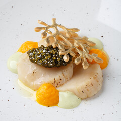Baked scallop with black caviar.