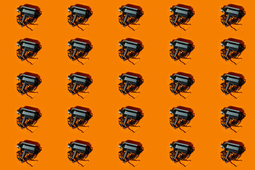 Mosaic with an old vintage video camera to film on an orange background.