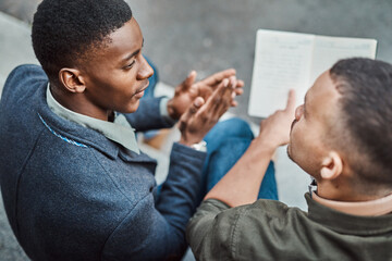 Constructing the perfect recipe for success. Shot of two young businessmen having an informal meeting against an urban background.