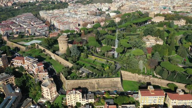 Aerial drone video of Saint Peter's gardens of world's largest church -Basilica of St. Peter's, Vatican and iconic Capella Sistine, Rome, Italy