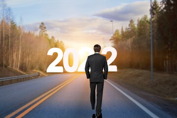 The 2022 New Year journey and future vision concept. Businessman traveling on highway road