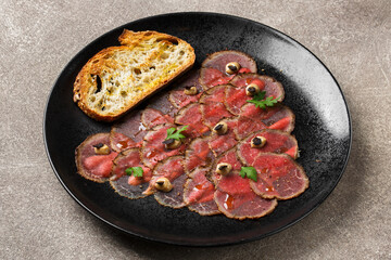 Marbled beef carpaccio served with toast and black garlic.