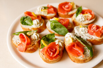 Bruschetta with salmon on a white tray.