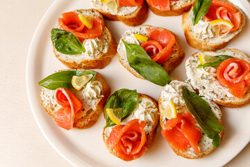 Bruschetta with salmon on a white tray.