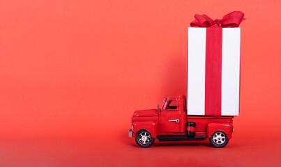 Red truck with a large gift box and a red bow