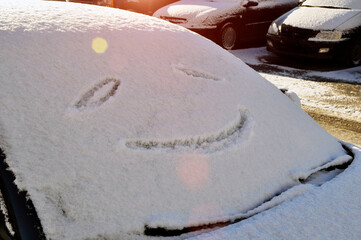 Obraz premium A smile on a snow-covered windshield of a car.