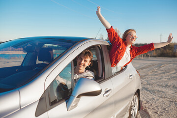 Happy couple traveling together. Man and woman having fun in the trip. Car sharing for young people.
