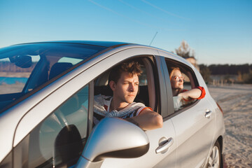 Happy couple traveling together. Man and woman having fun in the trip. Car sharing for young people.