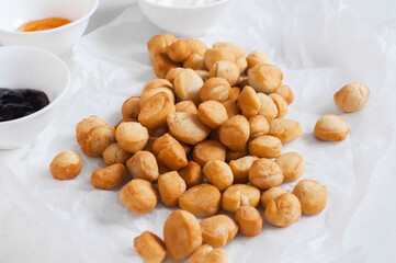 Shi-baursak, Kazakh traditional fried dounuts served on a parchment paper on a white background. Festive sweet baking.