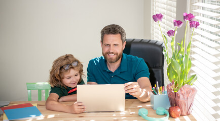 cheerful father and child son at school working online on laptop, knowledge