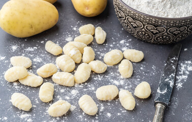 Fototapeta na wymiar Uncooked italian pasta gnocchi over stone background