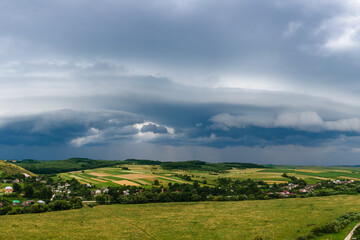 Fototapeta na wymiar Landscape of dark clouds forming on stormy sky during thunderstorm over rural area