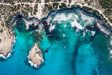 Top view of a beautiful sea harbor. Lagoon with turquoise water. Waves near rocky coast.