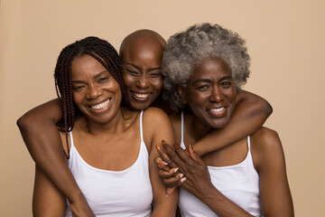 Studio portrait of three smiling women in white tops