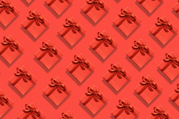 Many bright red gift boxes with ribbon on a red background. Top view. Pattern