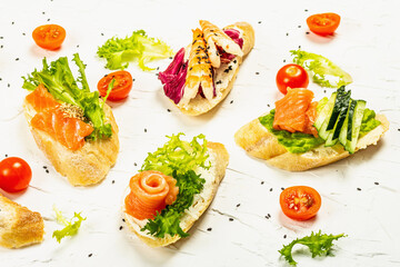 Assorted open sandwiches with salted salmon, shrimps, cream cheese, salad leaves and cherry tomatoes