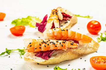 Open sandwiches with boiled shrimps, cream cheese, salad leaves, and cherry tomatoes