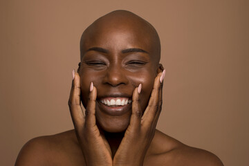 Studio portrait of smiling woman with shaved head
