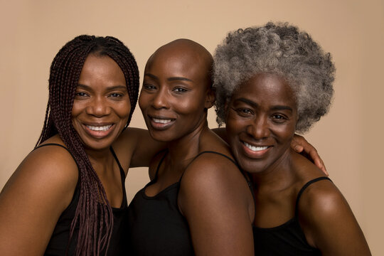 Studio portrait of three smiling women in black tops
