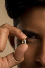 Close-up of man holding oil capsule