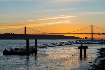 Fototapeta na wymiar Sunset on the background of the bridge in Lisbon.