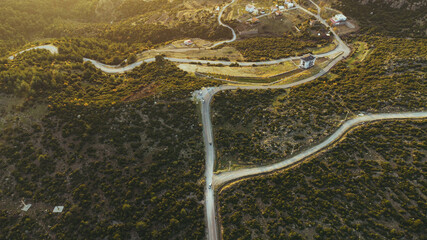 Top view of a bending single lane road among bushes.