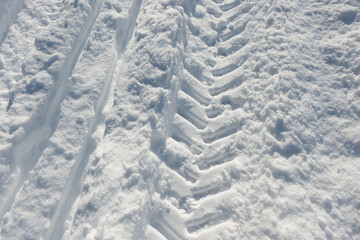 Fototapeta na wymiar tractor tire tracks and ski trail in the snow