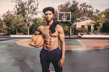 USA, Pennsylvania, Philadelphia, Portrait of shirtless man with basketball ball - obrazy, fototapety, plakaty