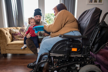 Woman on wheelchair playing with family at home