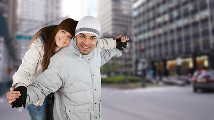 Smiling man and happy woman in the city. Young multiethnic couple in cold clothes walking