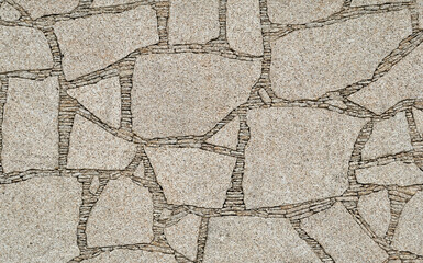 Textura de parede construida com pedras encaixadas com pedras mais pequenas no preenchimento das...