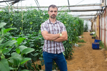 Portrait of confident farm owner with arms crossed in greenhouse