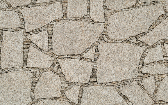 Textura de parede construida com pedras encaixadas com pedras mais pequenas no preenchimento das frechas