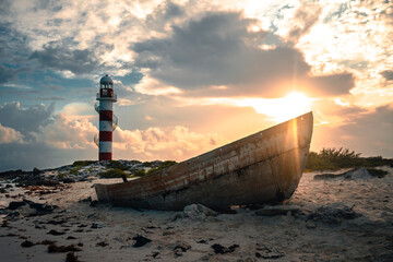 Faro / lighthouse y barca en la playa al amanecer