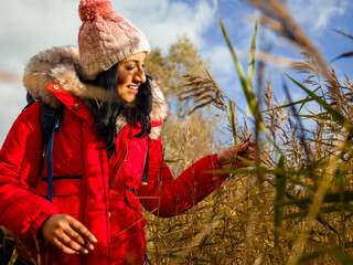 Fototapeta na wymiar Smiling female hiker touching grass