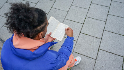 Young man reading book outdoors