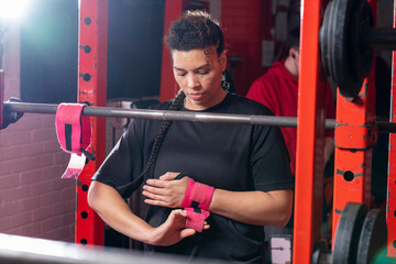 Woman bandaging her wrists before weightlifting training