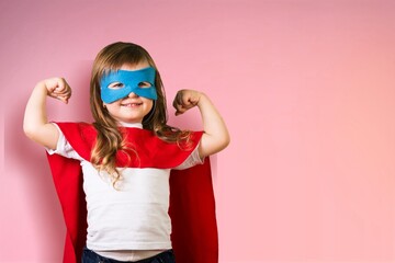 Portrait of little kid. Funny little power superhero kid showing muscles.