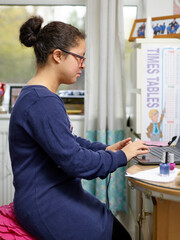 Girl with Down Syndrome using laptop at home
