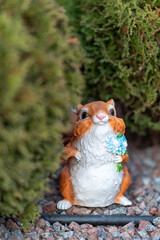 garden figurine of a squirrel near boxwood