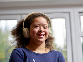 Portrait of smiling girl with Down Syndrome with headphones