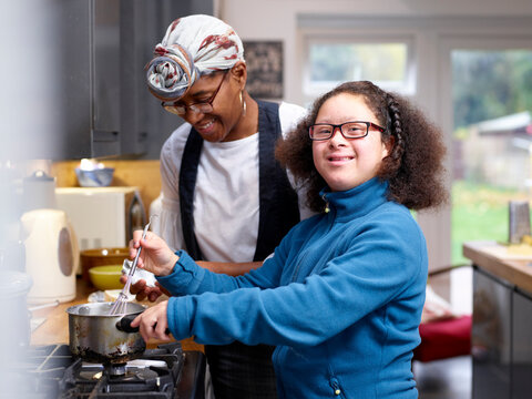Mother with daughter with Down Syndrome cooking together