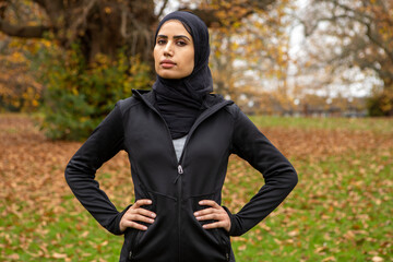 Portrait of woman in black sports clothing and hijab in park