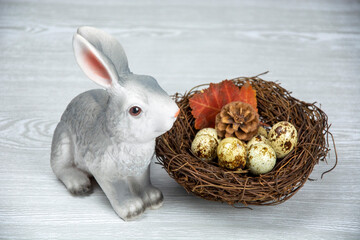 Easter Bunny and Easter eggs in the nest. Spring composition on a light background.