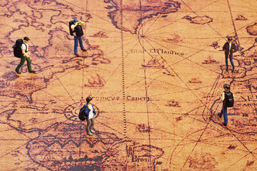 Miniature travellers standing on map. Travel concept