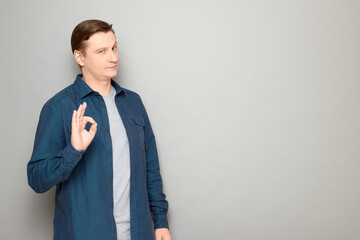 Portrait of confident mature man showing okay gesture and smiling