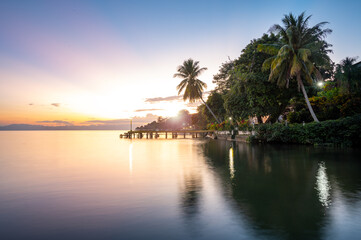 sunset on tropical river beach with palm trees, long exposure - Río Dulce,  Izabal, Guatemala
